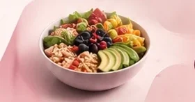 A bowl of grains, fruit and vegetables.